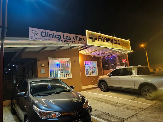 Fachada de Clínica Las Villas de noche, con el letrero encendido al lado de Farmacia Real, en Villas de Arraiján